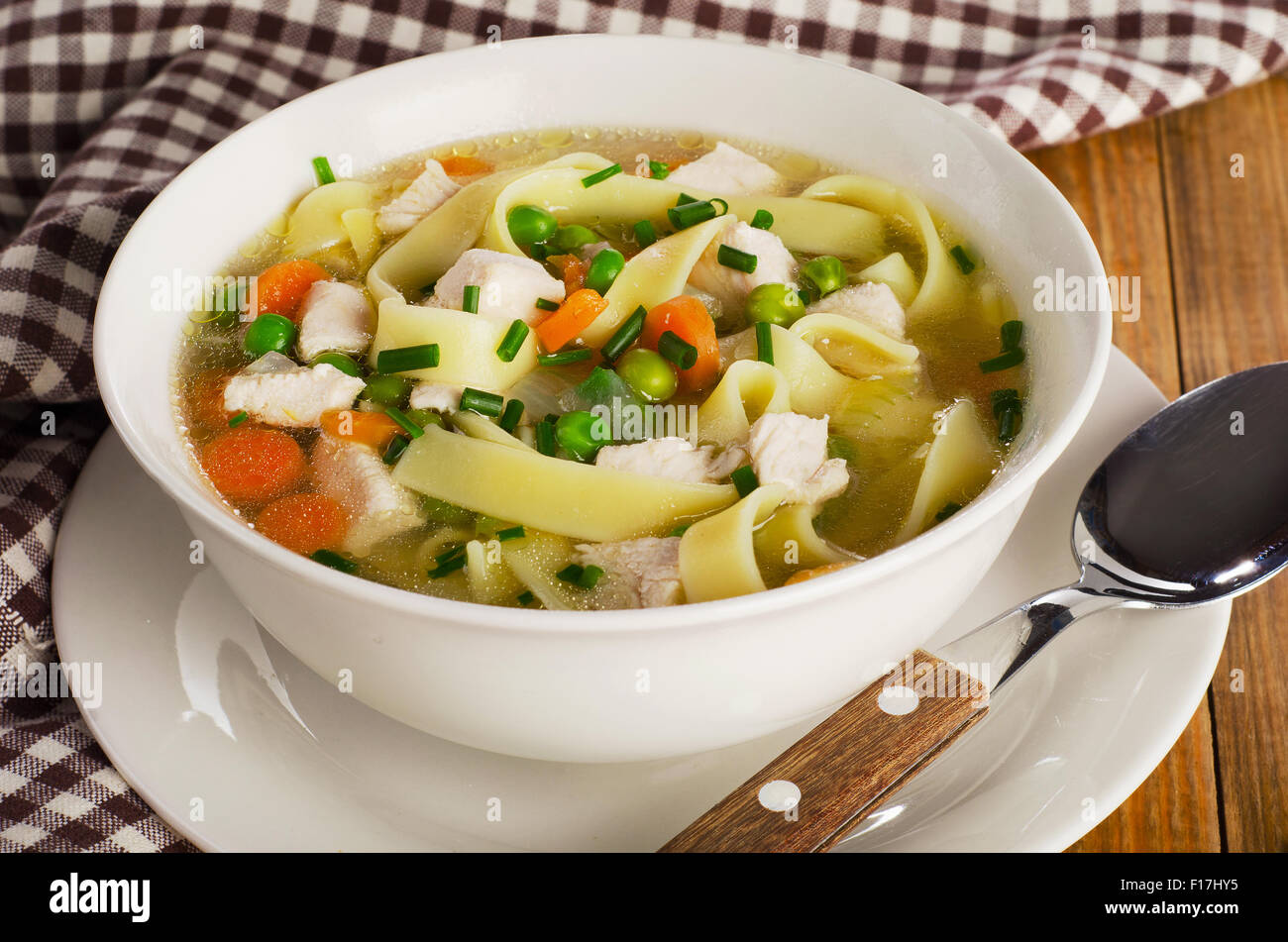 Ciotola di pollo zuppa di noodle su un vecchio tavolo di legno. Messa a fuoco selettiva Foto Stock