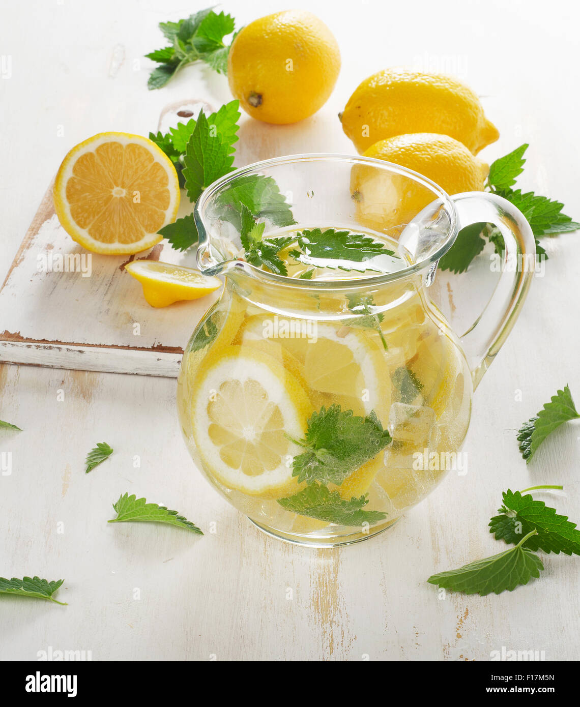 Acqua fredda con limone fresco e foglie di menta in una caraffa di vetro. Messa a fuoco selettiva Foto Stock