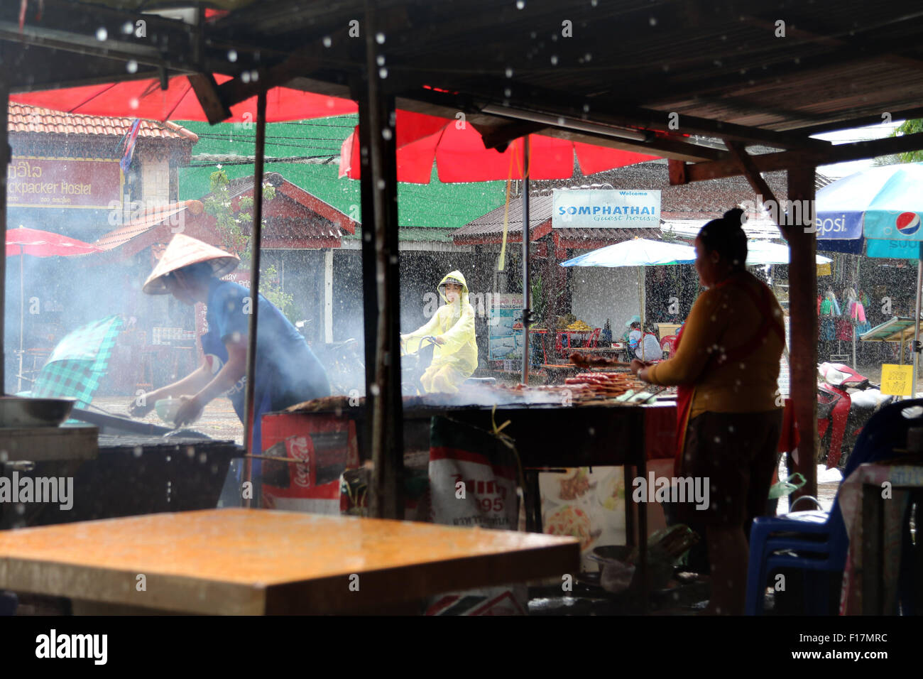 Cucina di strada i venditori nella tempesta di pioggia Foto Stock