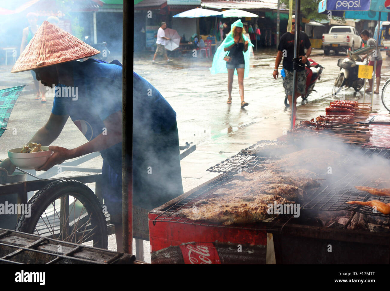 Cibo di strada il barbecue di pesce BBQ sfrigolanti nella piovosa cittadina Foto Stock