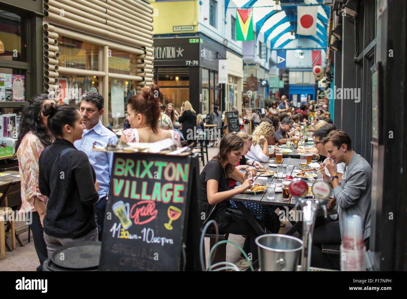 Brixton Village market, Londra, Regno Unito. Persone gustare del cibo e delle bevande nel villaggio di Brixton, Brixton iconici mercato coperto. Foto Stock