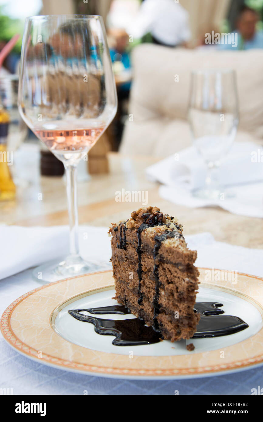 Pezzo di torta al cioccolato e un bicchiere di vino in una tabella Foto Stock