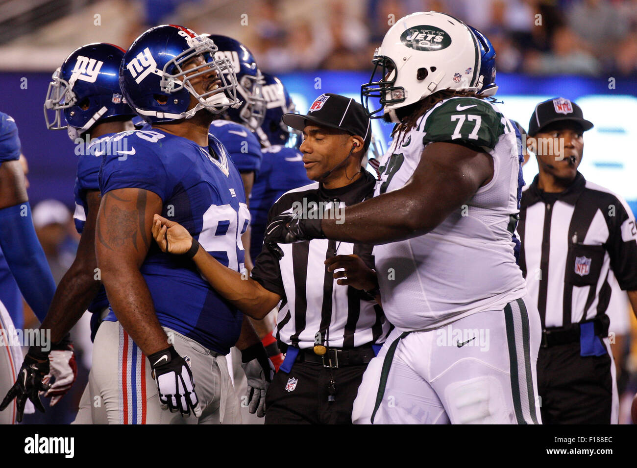 East Rutherford, New Jersey, USA. Il 29 agosto, 2015. New York Giants tackle difensivo Cullen Jenkins (99) e New York getti guard James Carpenter (77) presentano alcune parole come il funzionario tenta di separarli durante la NFL preseason game tra il New York getti e New York Giants a MetLife Stadium di East Rutherford, New Jersey. Credito: Cal Sport Media/Alamy Live News Foto Stock