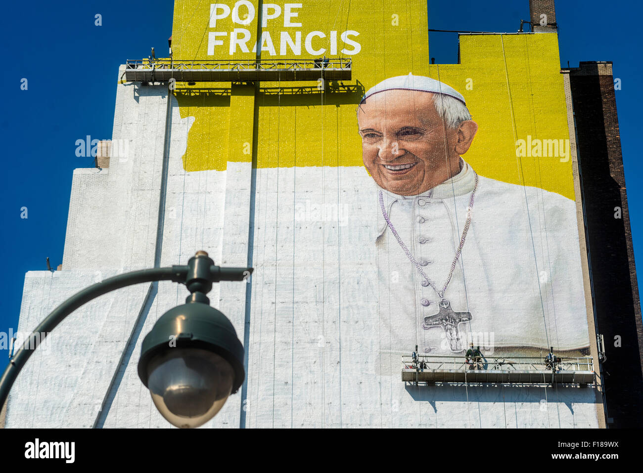 New York, Stati Uniti d'America. 29 Agosto, 2015. Un murale di Papa Francesco emerge in Midtown come la città si prepara per la visita del Papa in settembre. Il digital signage è uno spazio di circa 225 metri e alta 93 metri, secondo Lamar pubblicità esterna, che ha affittato la parete e venduto uno spazio pubblicitario su di esso per molti anni. I pittori si aspettano di utilizzare circa 100 galloni di pittura murale che resteranno in vigore per sei settimane di credito: Stacy Rosenstock Walsh/Alamy Live News Foto Stock