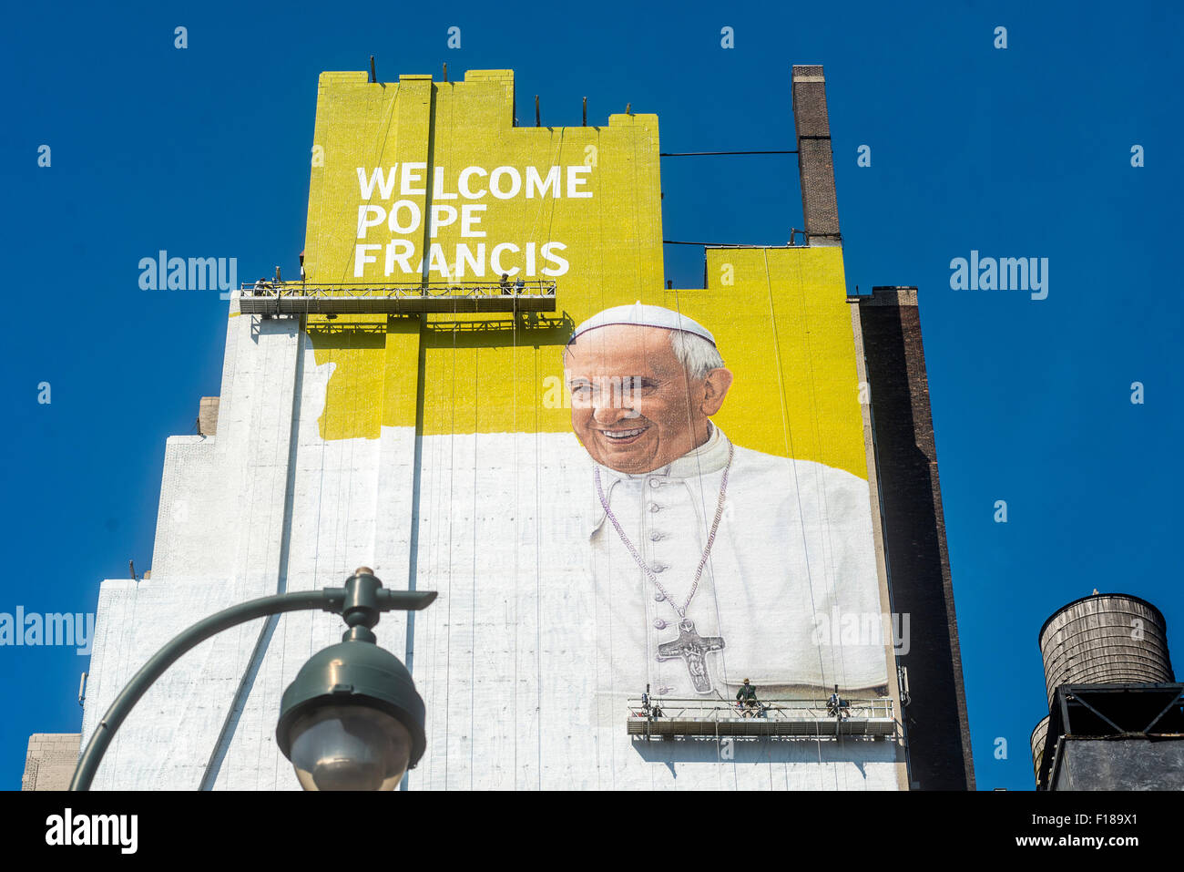 New York, Stati Uniti d'America. 29 Agosto, 2015. Un murale di Papa Francesco emerge in Midtown come la città si prepara per la visita del Papa in settembre. Il digital signage è uno spazio di circa 225 metri e alta 93 metri, secondo Lamar pubblicità esterna, che ha affittato la parete e venduto uno spazio pubblicitario su di esso per molti anni. I pittori si aspettano di utilizzare circa 100 galloni di pittura murale che resteranno in vigore per sei settimane di credito: Stacy Rosenstock Walsh/Alamy Live News Foto Stock