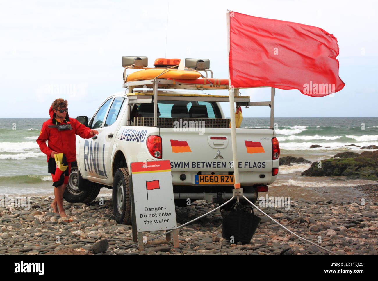 Una Toyota Hilux RNLI Lifeguard veicolo con una spia rossa bandiera che vieta la balneazione sulla spiaggia. Foto Stock