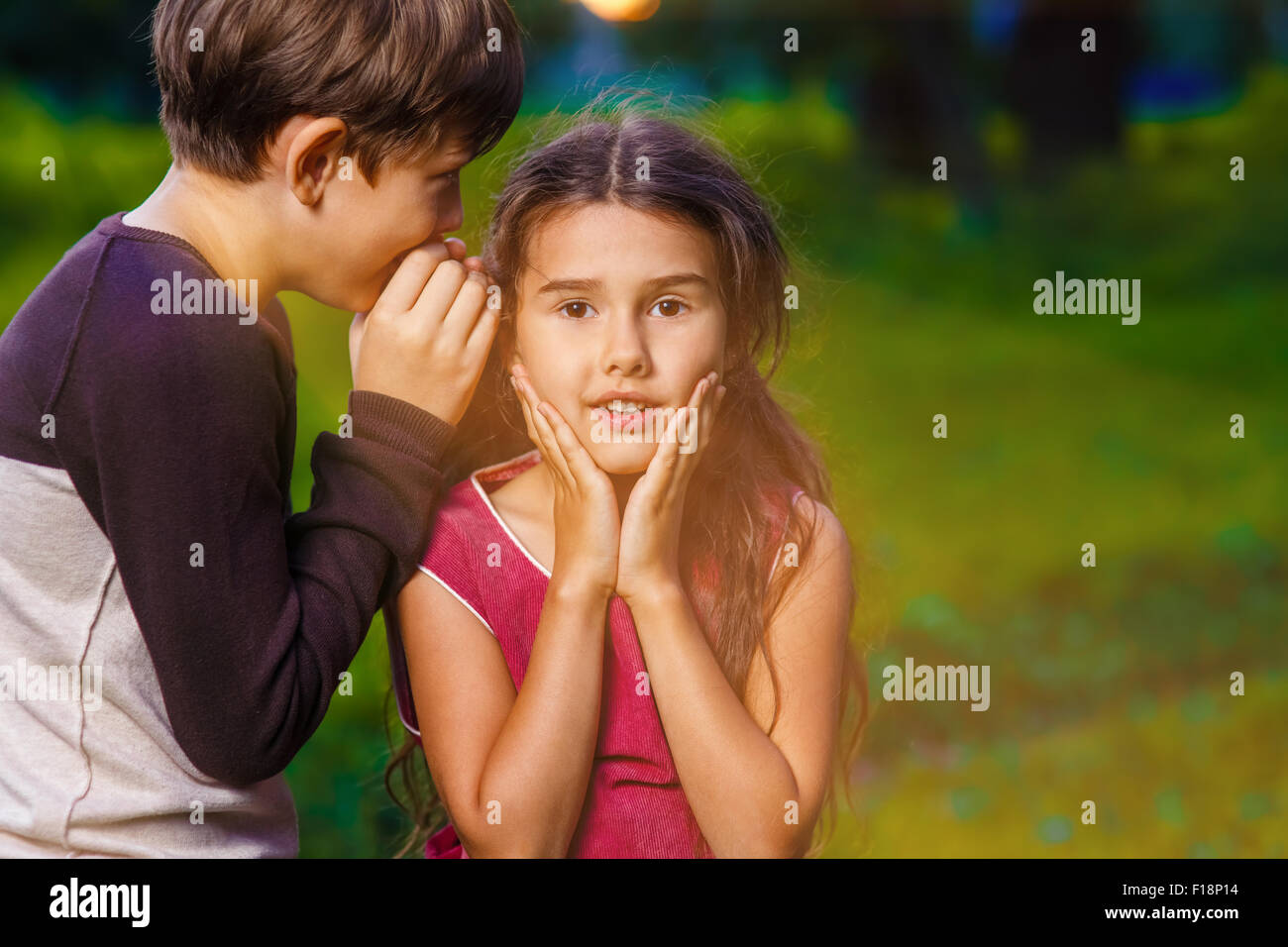 Ragazza ragazzo sussurra all'orecchio segreto rumors dice in natura foto Foto Stock