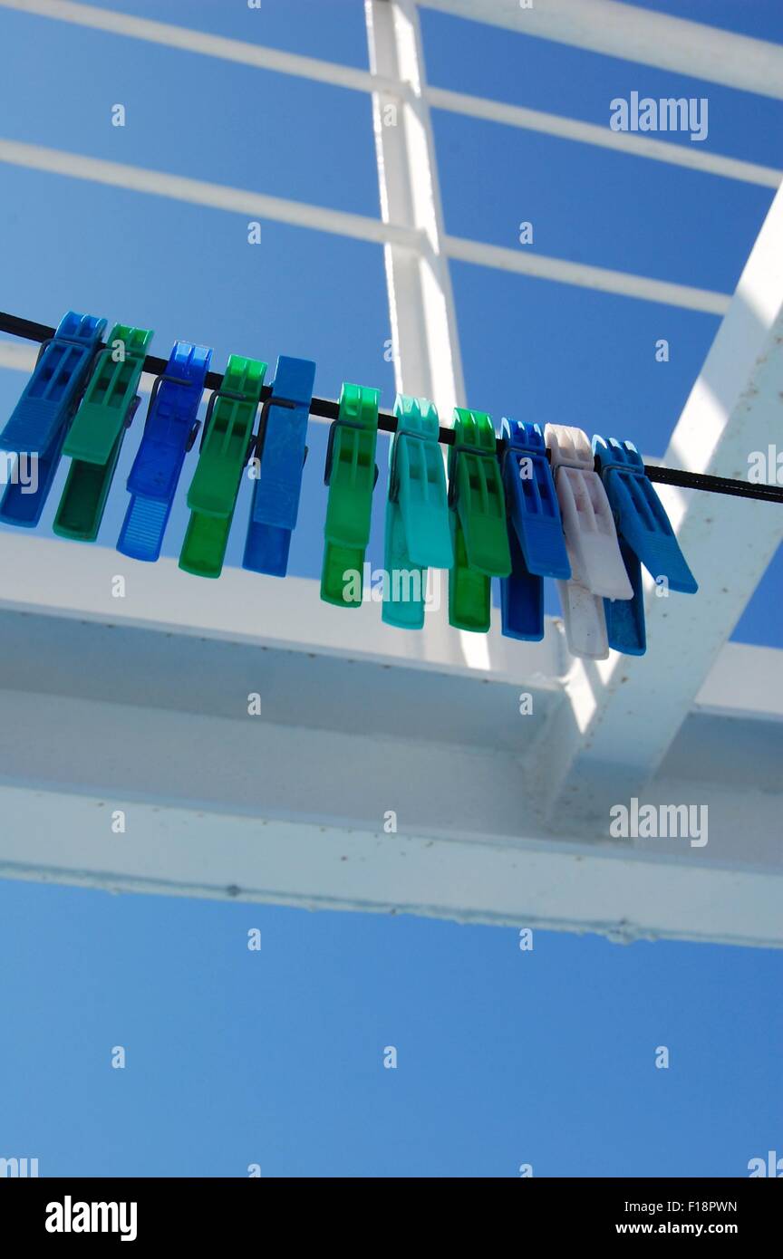 Il blu e il verde dei pioli in plastica su una linea su un traghetto greco contro un cielo blu Foto Stock