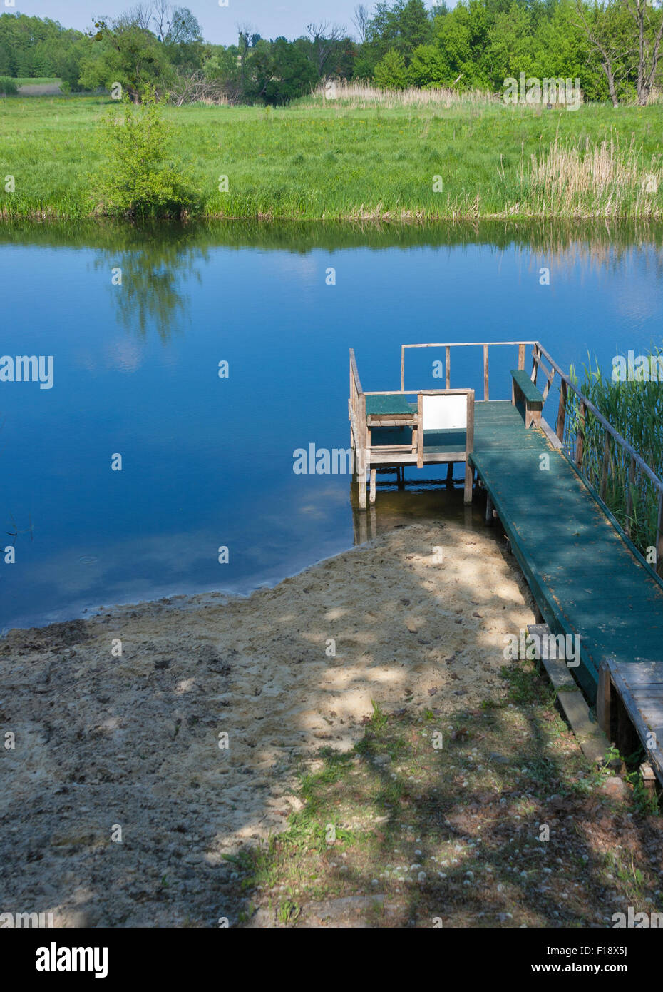 Ponte di legno per il nuoto e la pesca in un piccolo e tranquillo fiume. fiume Ros, Ucraina. Foto Stock