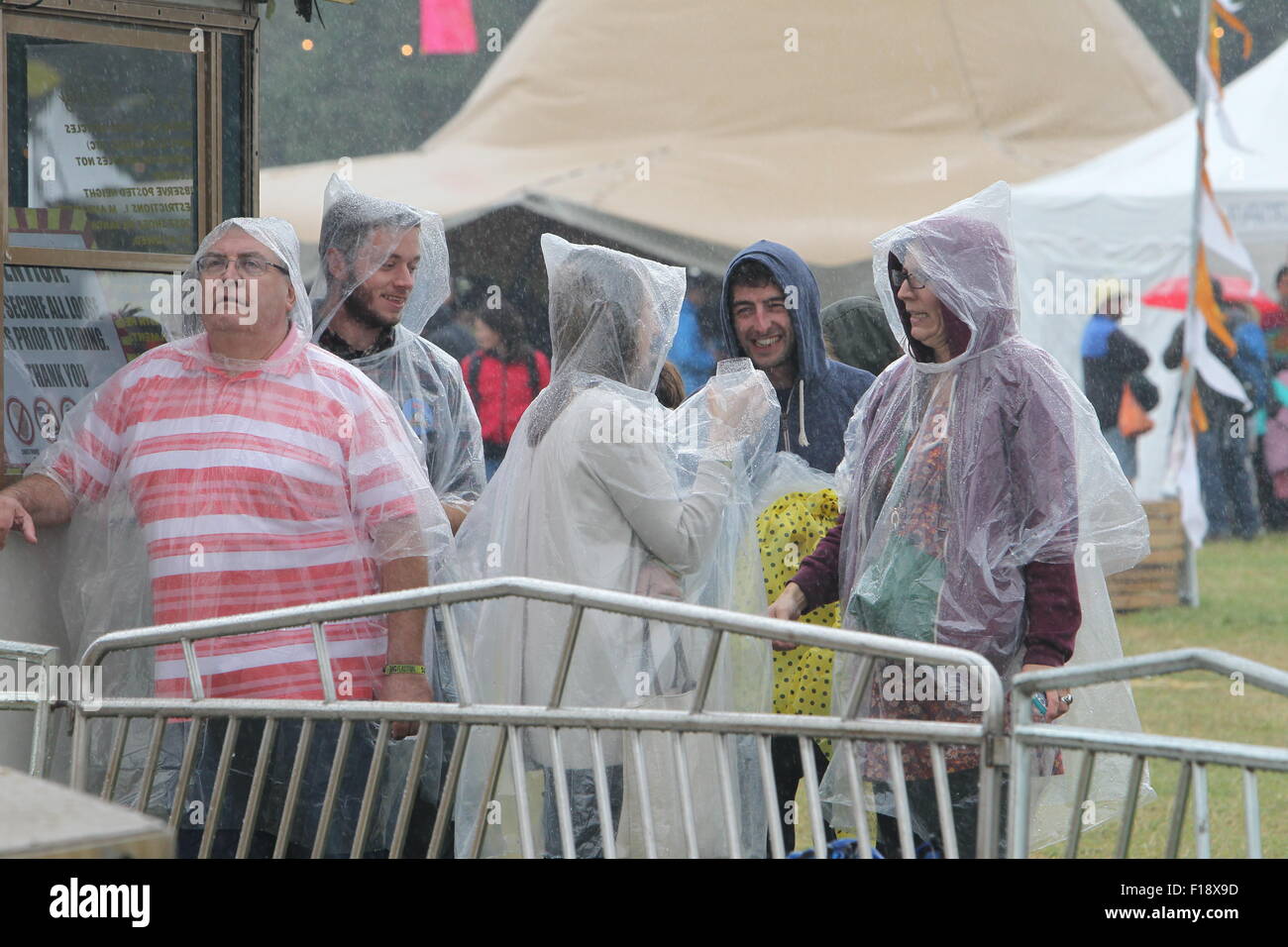 Kingham, Oxfordshire, Regno Unito, domenica 30 agosto 2015. Sorridere nonostante il fatto di essere imbevuto - visitatori al Big Feastival cibo e musica festival organizzato dallo chef Jamie Oliver e sfumare con il bassista Alex James su James' farm in Oxfordshire erano determinati a divertirsi nonostante la pioggia. Immagine: Ric Mellis 30/08/2015 Kingham, Oxfordshire, Regno Unito catchline: Feastival Domenica Credito: Ric Mellis/Alamy Live News Foto Stock