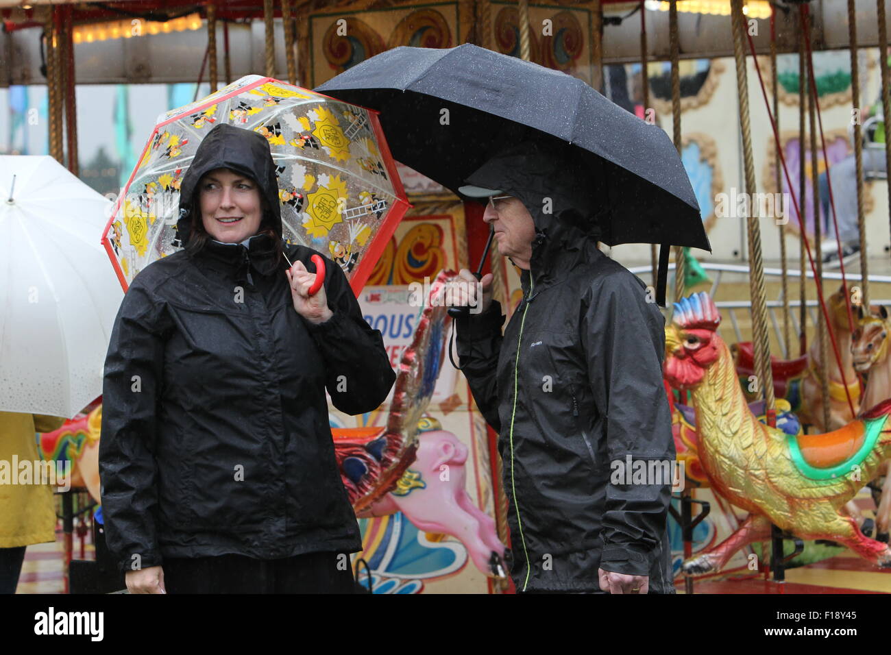 Kingham, Oxfordshire, Regno Unito, domenica 30 agosto 2015. Sorridere nonostante il fatto di essere imbevuto - visitatori al Big Feastival cibo e musica festival organizzato dallo chef Jamie Oliver e sfumare con il bassista Alex James su James' farm in Oxfordshire erano determinati a divertirsi nonostante la pioggia. Immagine: Ric Mellis 30/08/2015 Kingham, Oxfordshire, Regno Unito catchline: Feastival Domenica Credito: Ric Mellis/Alamy Live News Foto Stock