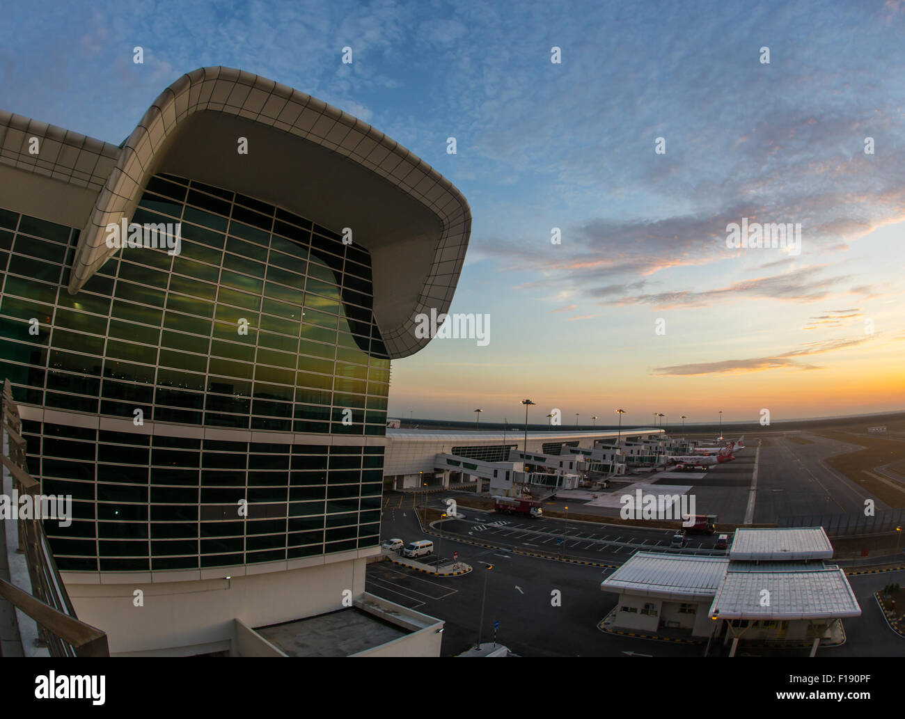 Piano di passeggero vola in alto su pista di decollo dall' aeroporto al tramonto Foto Stock