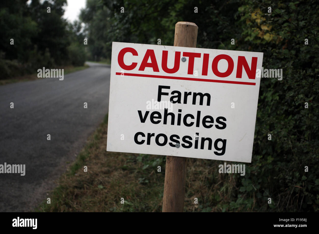 Attenzione Farm segno dei veicoli su strada rurale, Inghilterra Foto Stock