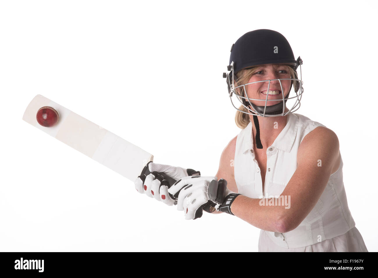 Femmina di cricket club giocatore di cricket di colpire la palla con la racchetta cricket Foto Stock