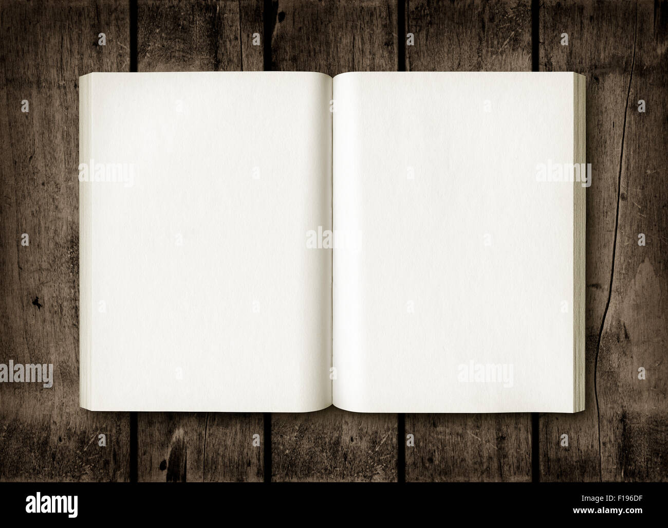 Libro aperto al buio su un tavolo di legno. Mockup Foto Stock