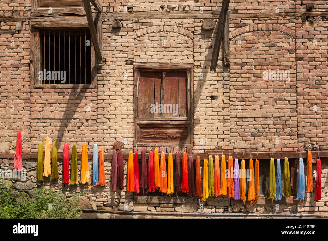 India, Jammu e Kashmir Srinagar, Città Vecchia, artigianato, tinti ricamo thread appesi fuori casa per asciugare Foto Stock