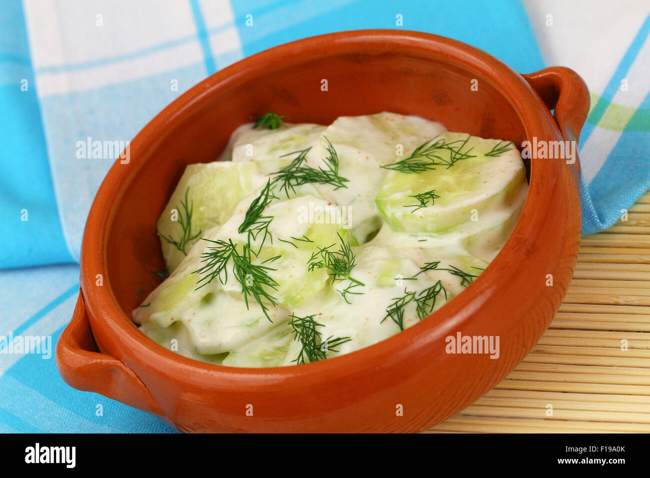 Insalata di cetrioli con panna acida e aneto fresco nel recipiente di argilla Foto Stock