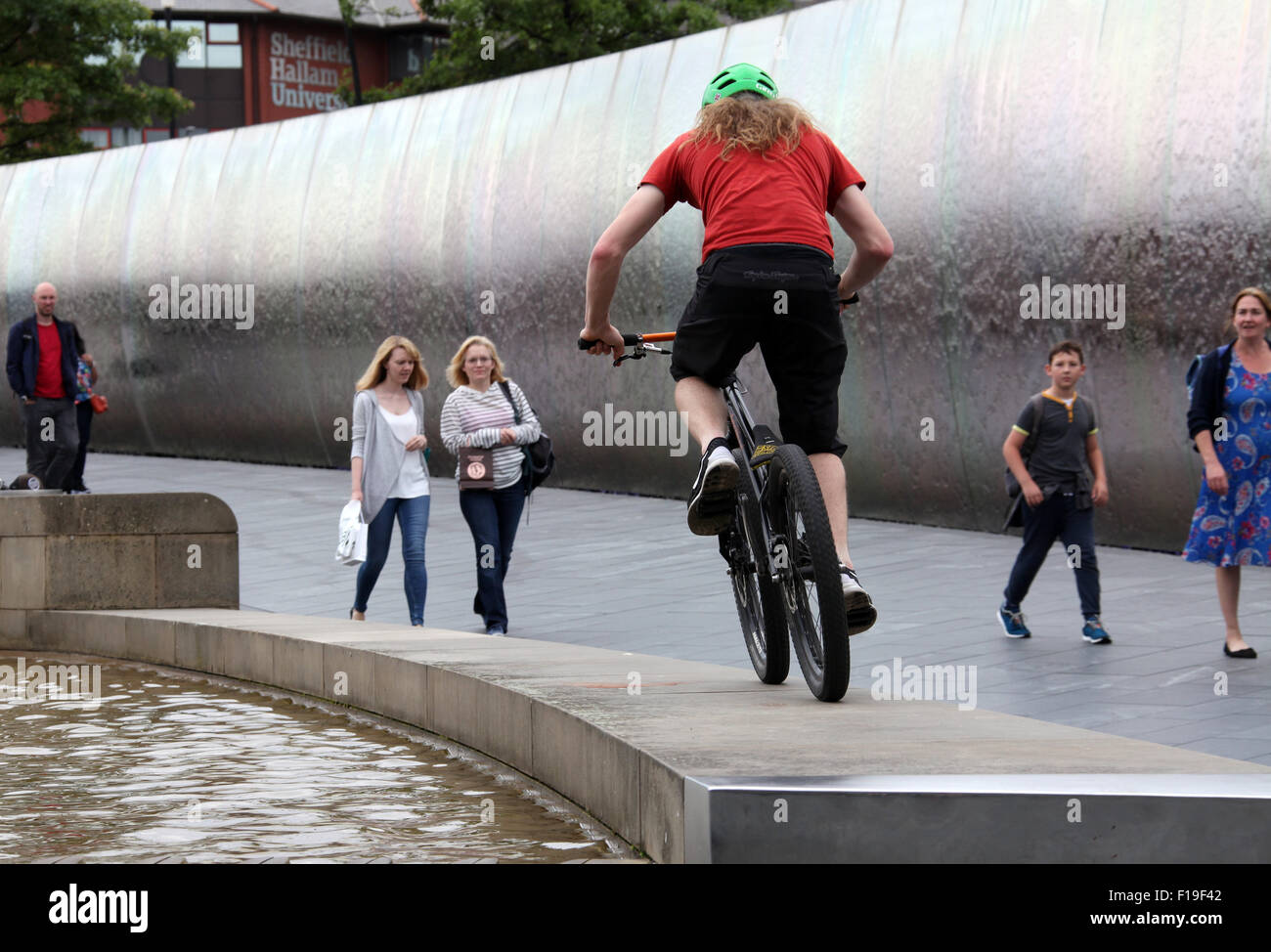 Stunt ciclista al bordo di taglio della scultura in acciaio e funzione di acqua al di fuori di Sheffield stazione ferroviaria Foto Stock
