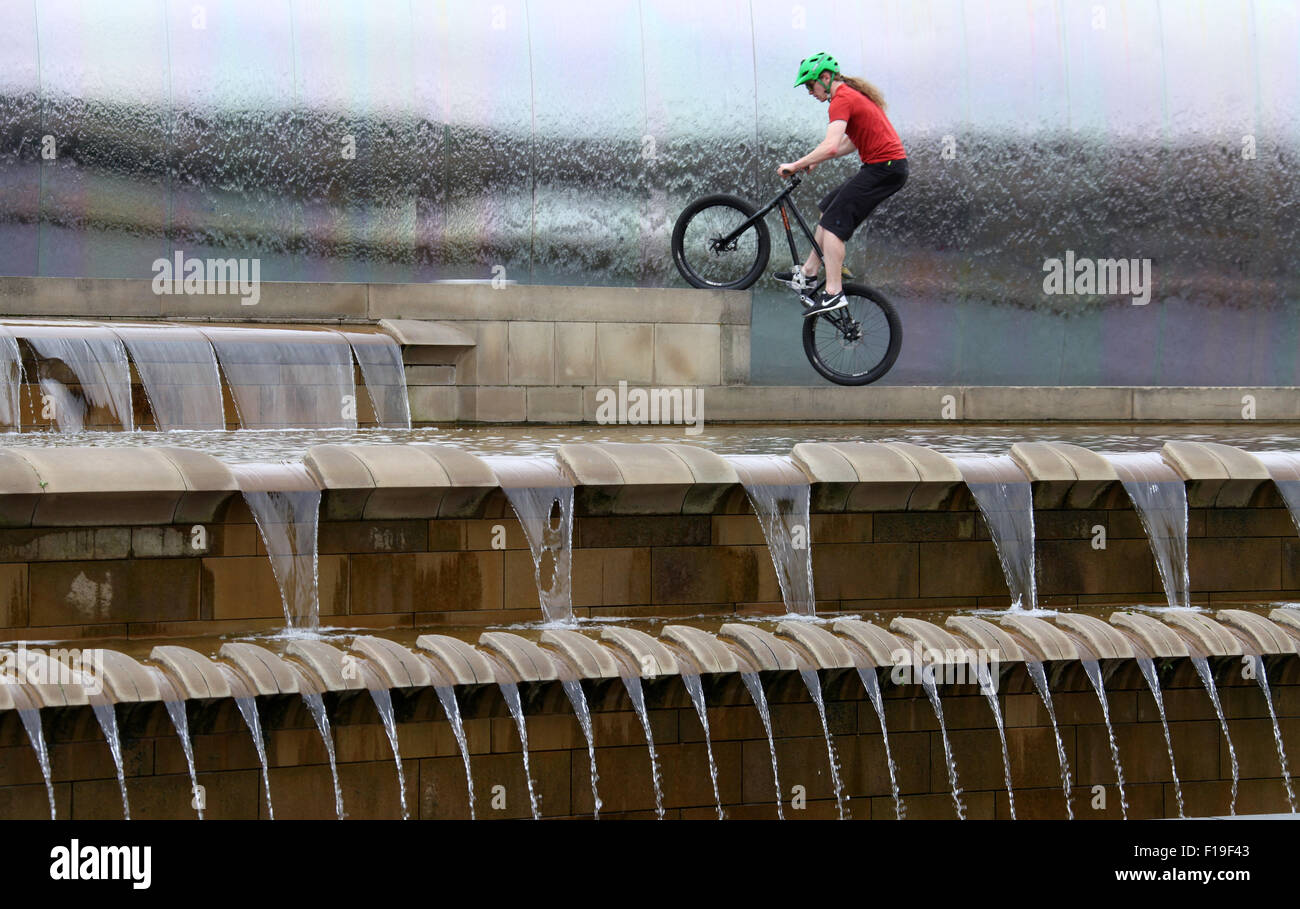 Stunt ciclista al bordo di taglio della scultura in acciaio e funzione acqua a Sheffield stazione ferroviaria Foto Stock