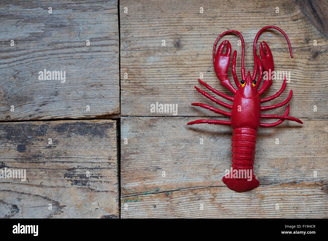 Red Lobster in plastica sul vecchio sfondo di legno Foto Stock