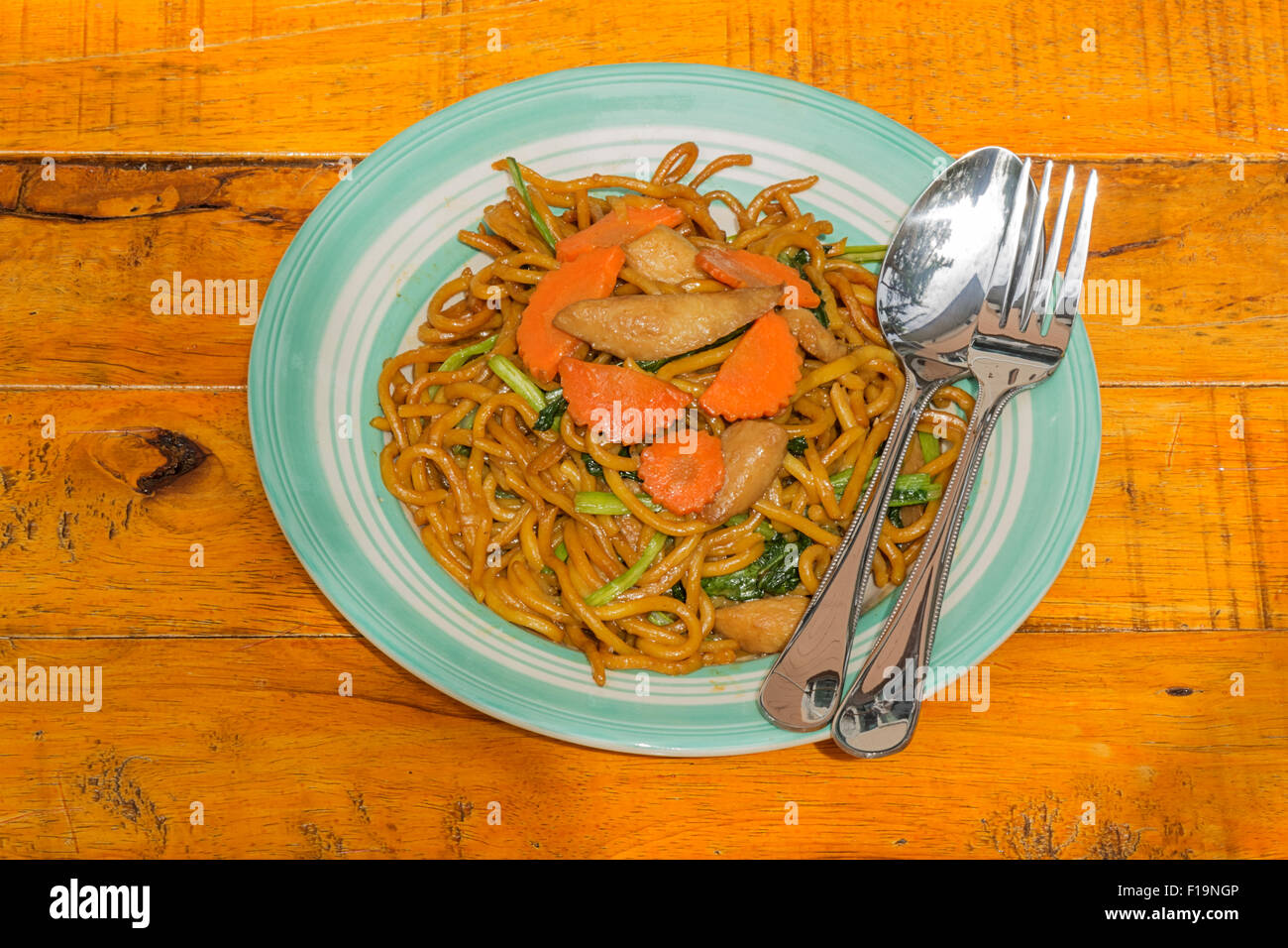 Spaghettini fritti su sfondo di legno Foto Stock