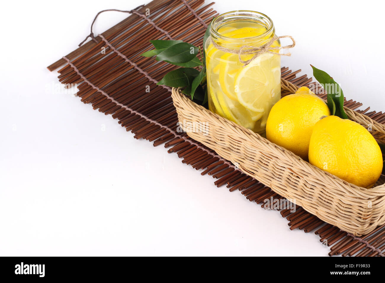 La limonata con un po' di limone non tagliata all'interno di un cestello pronto spazio copia Foto Stock