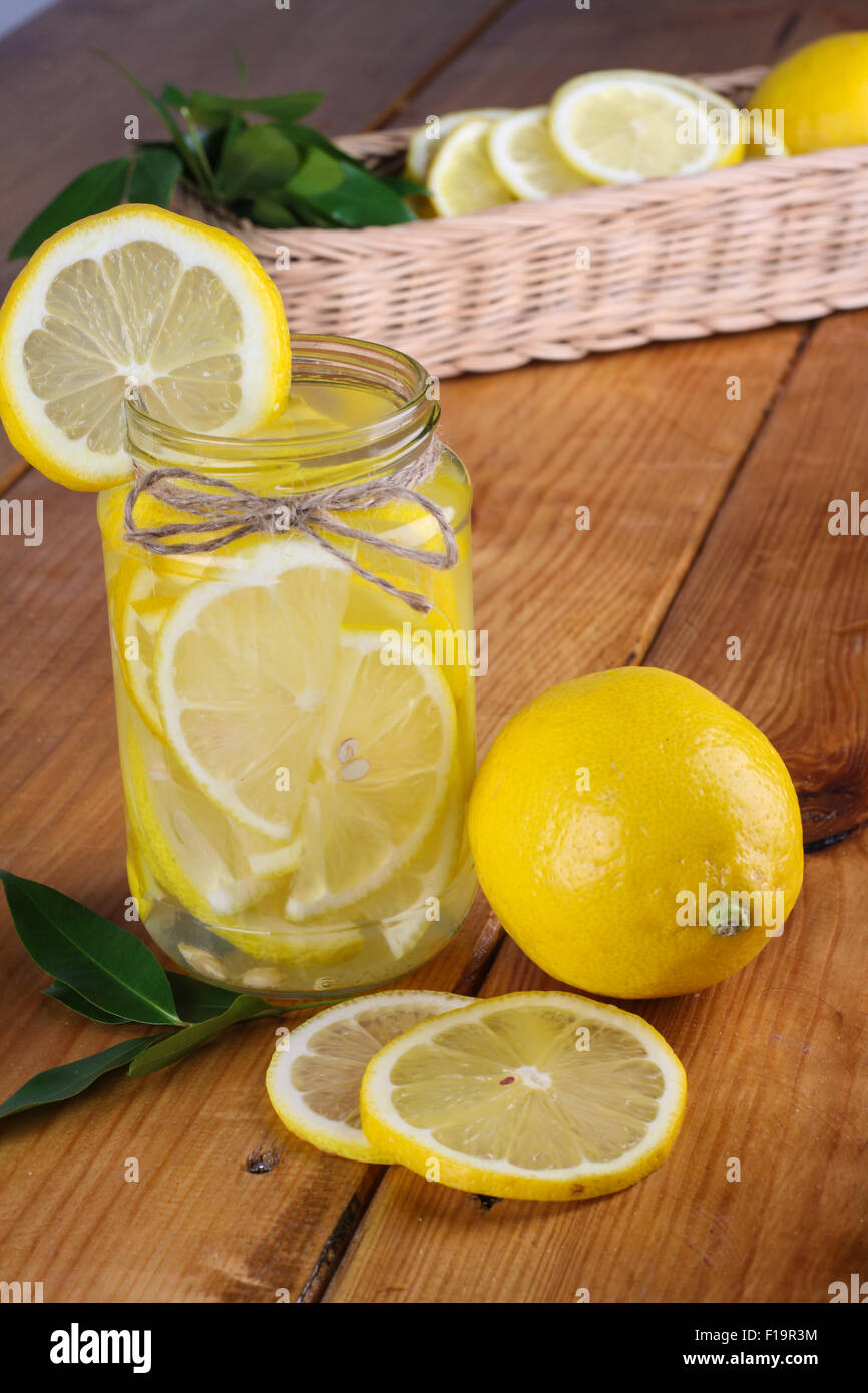 La limonata con alcuni freschi intonso limone giallo in cucina in legno tabella Foto Stock