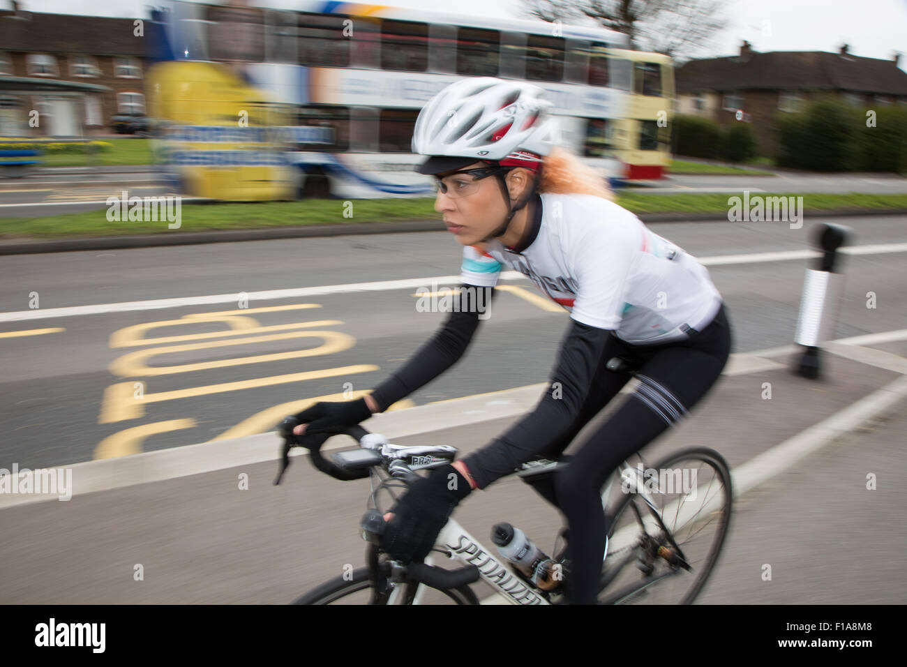 Ciclista femmina racing lungo una ampia pista ciclabile su Lewes Road, Brighton Foto Stock