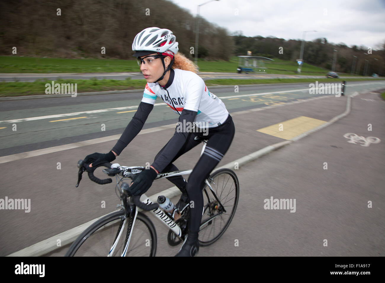 Ciclista femmina racing lungo una vasta designato pista ciclabile su Lewes Road, Brighton Foto Stock