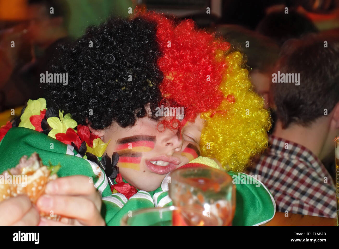 Berlino, Germania, ragazzo con parrucca e trucco nella nazionale tedesca schlaeft colori Foto Stock
