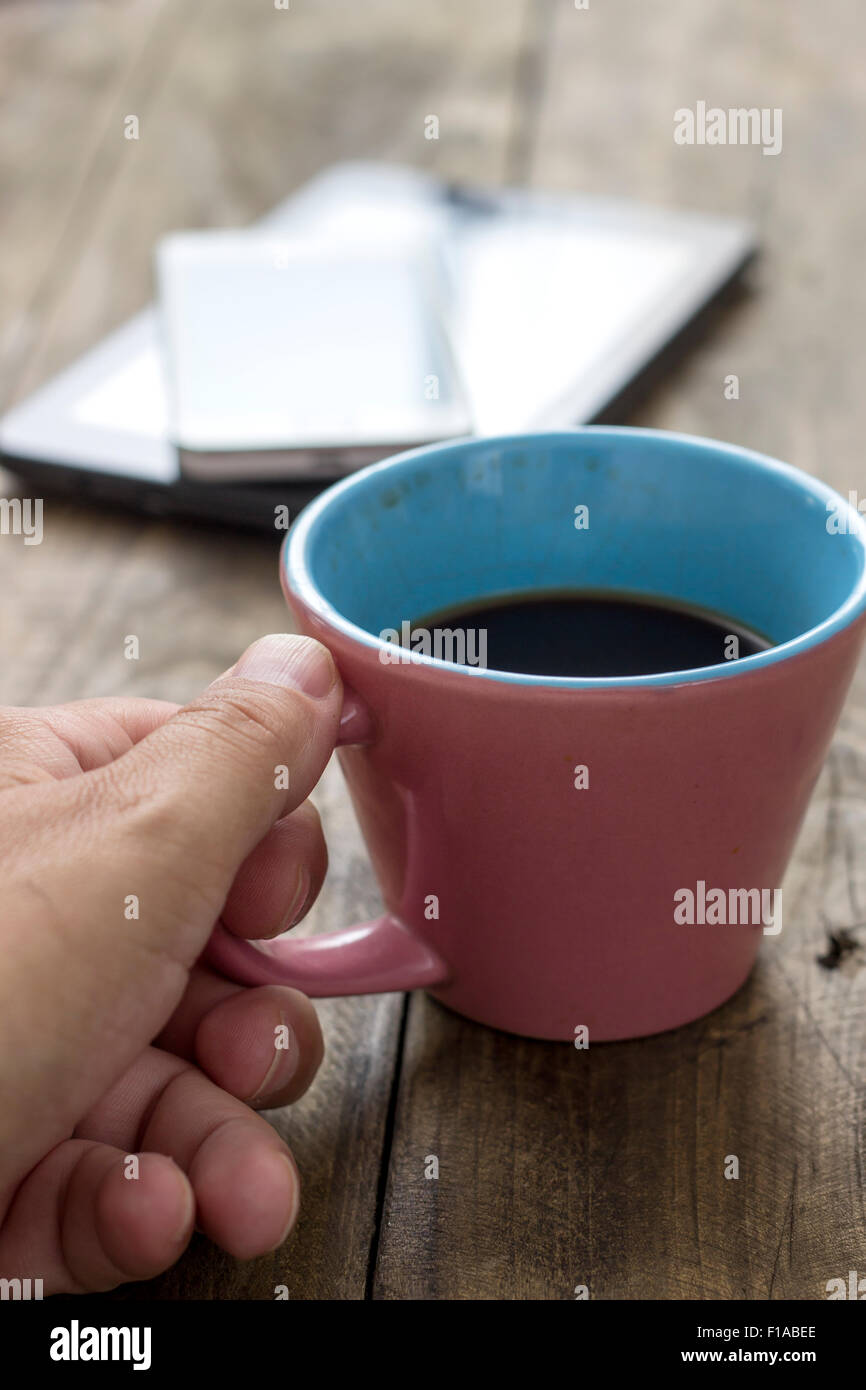 Mano azienda tazza di caffè su sfondo di legno, close up Foto Stock