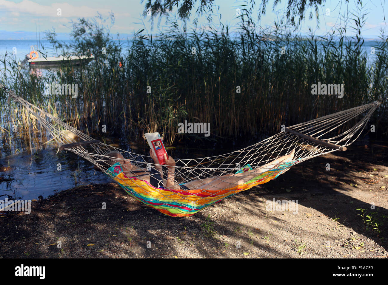 Il lago di Bolsena, Italia, ragazza distesa in un amaca e la lettura di un libro Foto Stock