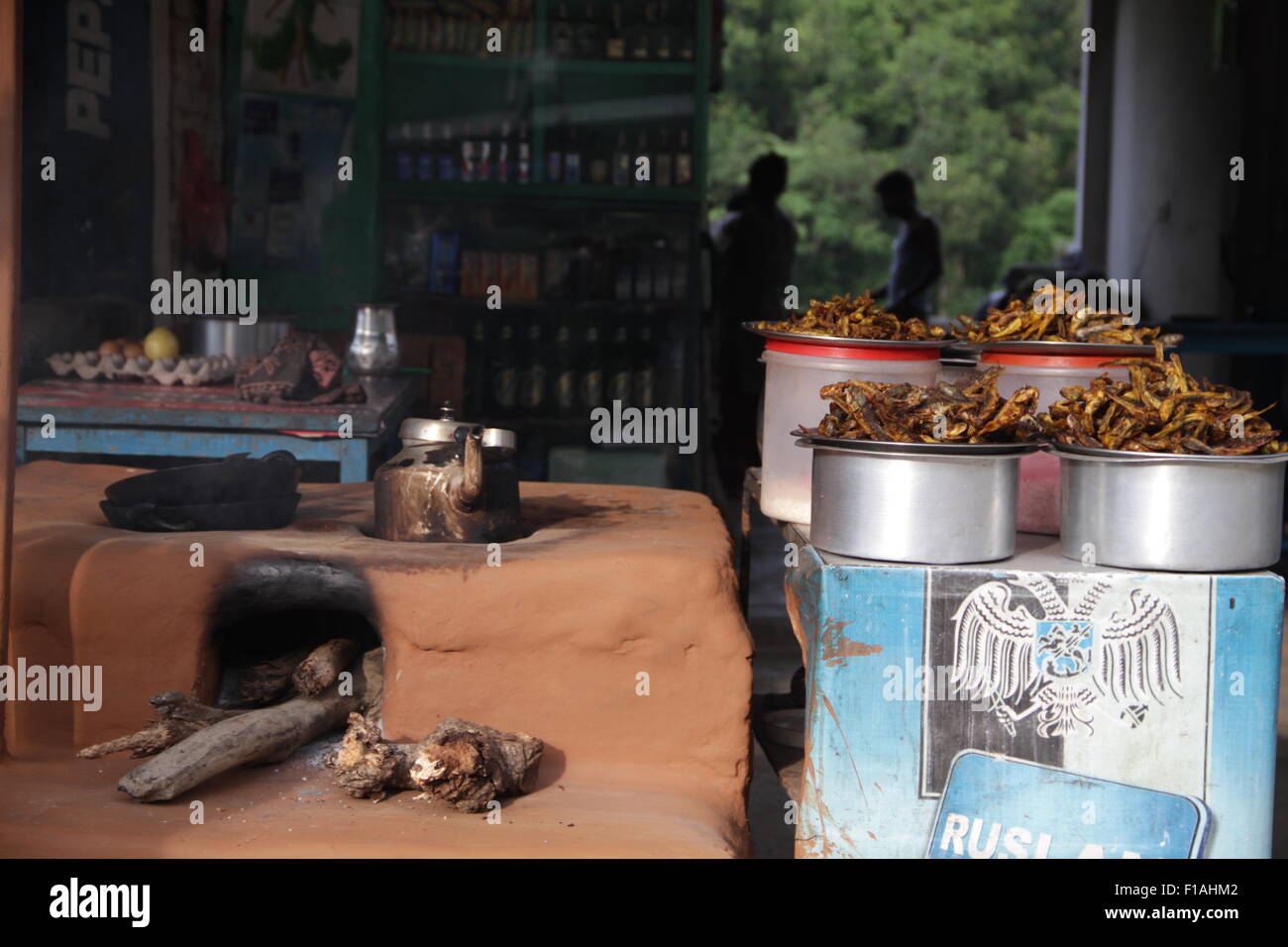 Una banchina cafe con fuoco di legno aperto la vendita di pesce cotto e tè vicino a Kathmandu su autostrada H04 Foto Stock