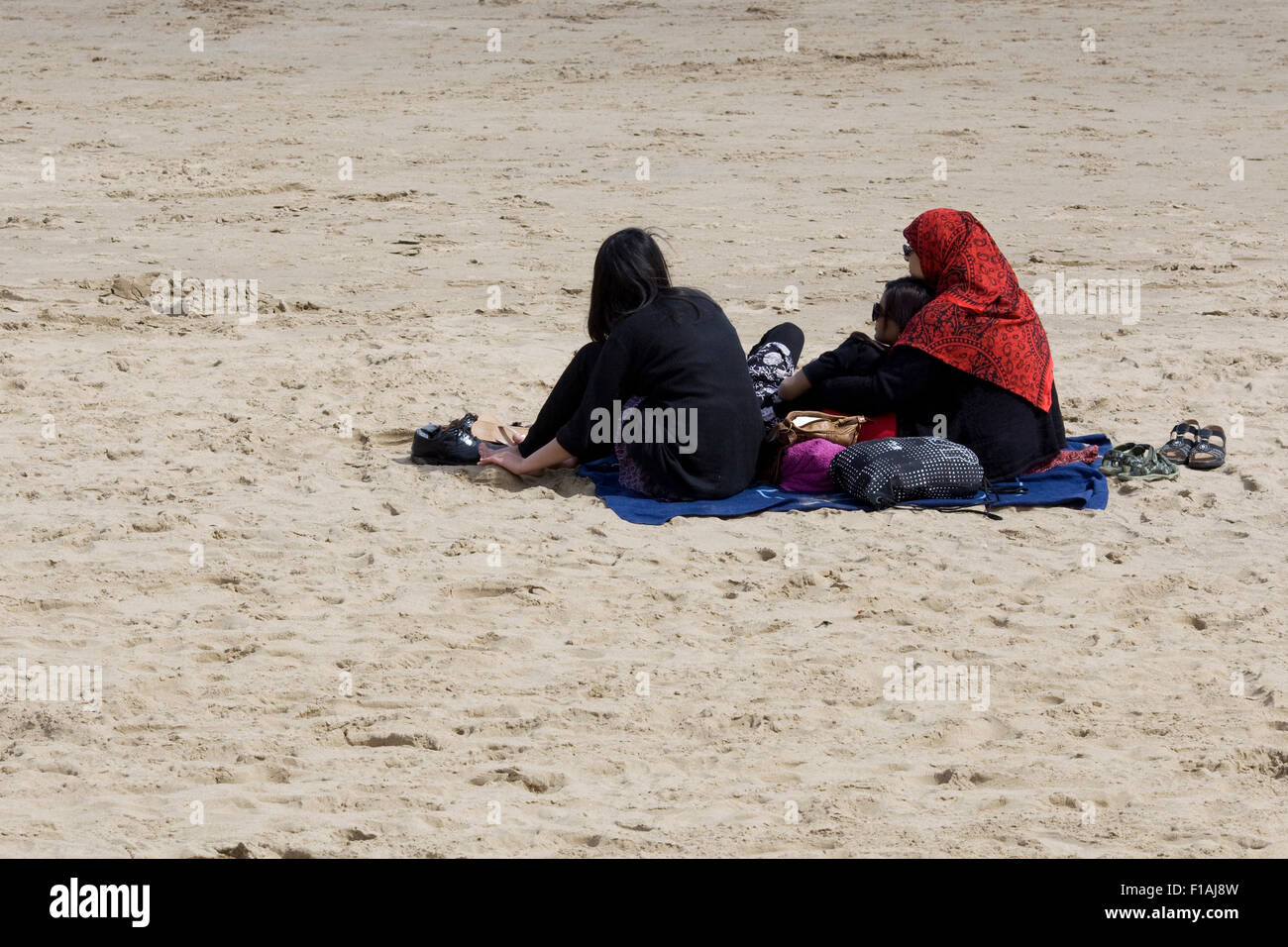 Famiglia asiatica seduto sulla spiaggia Foto Stock