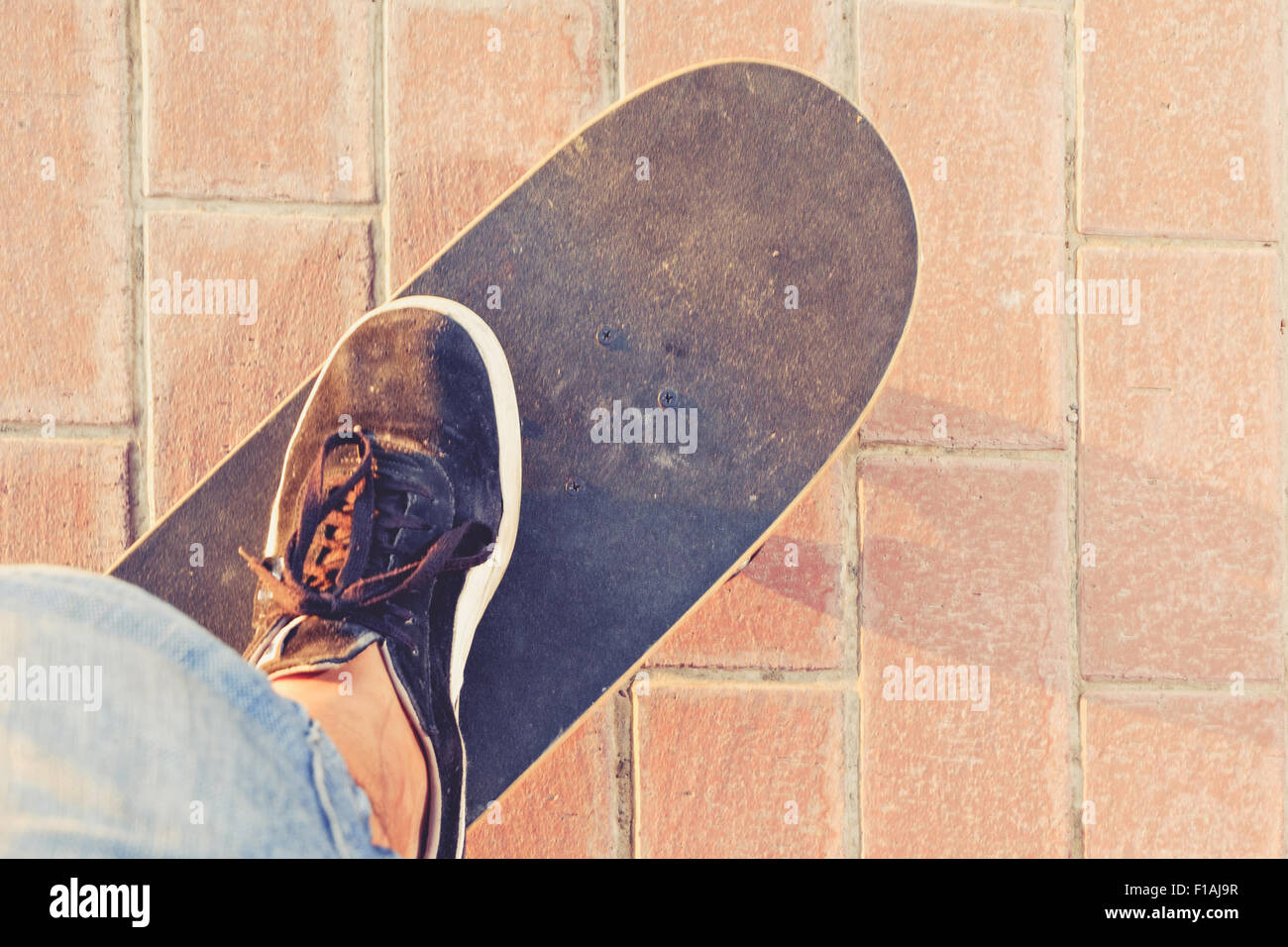 Skateboard vista dal al di sotto dello con piede in sneakers su Foto Stock