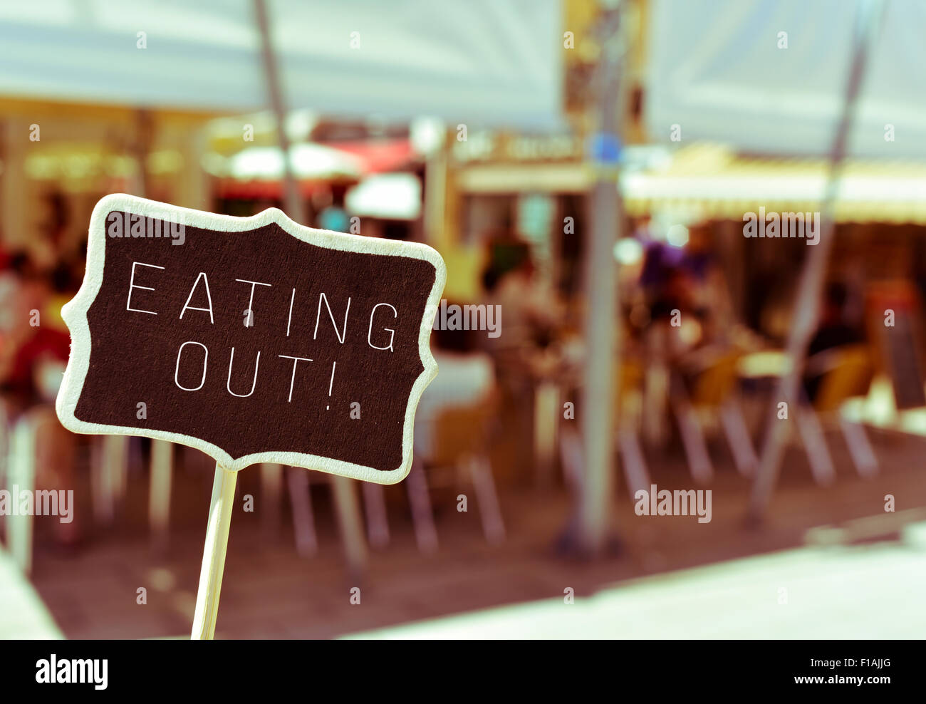 Primo piano di una lavagna con il testo di mangiare fuori in terrazza occupato di un ristorante Foto Stock