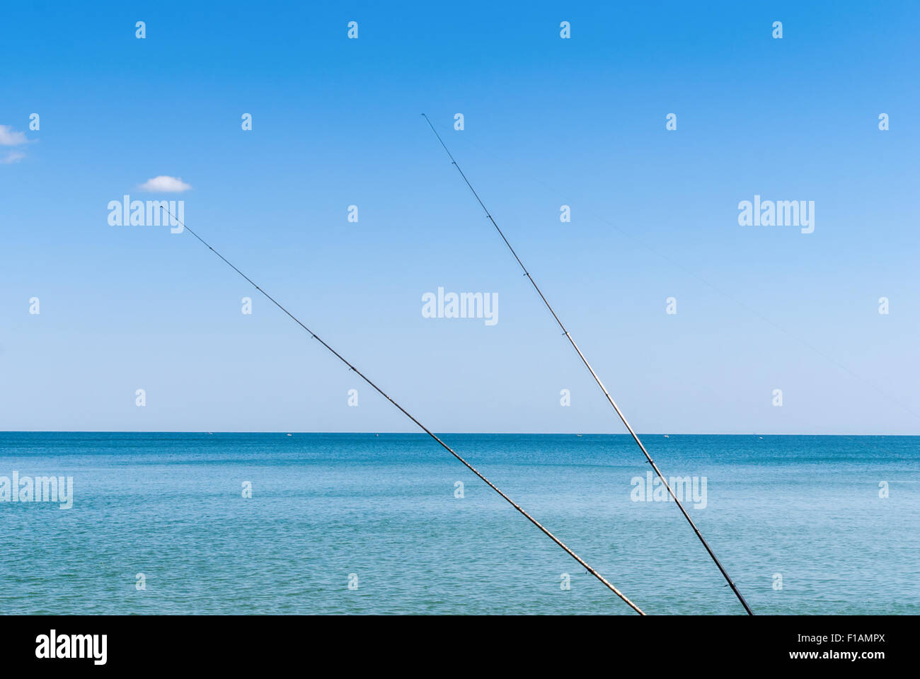 Canne da pesca sullo sfondo di acqua blu Foto Stock