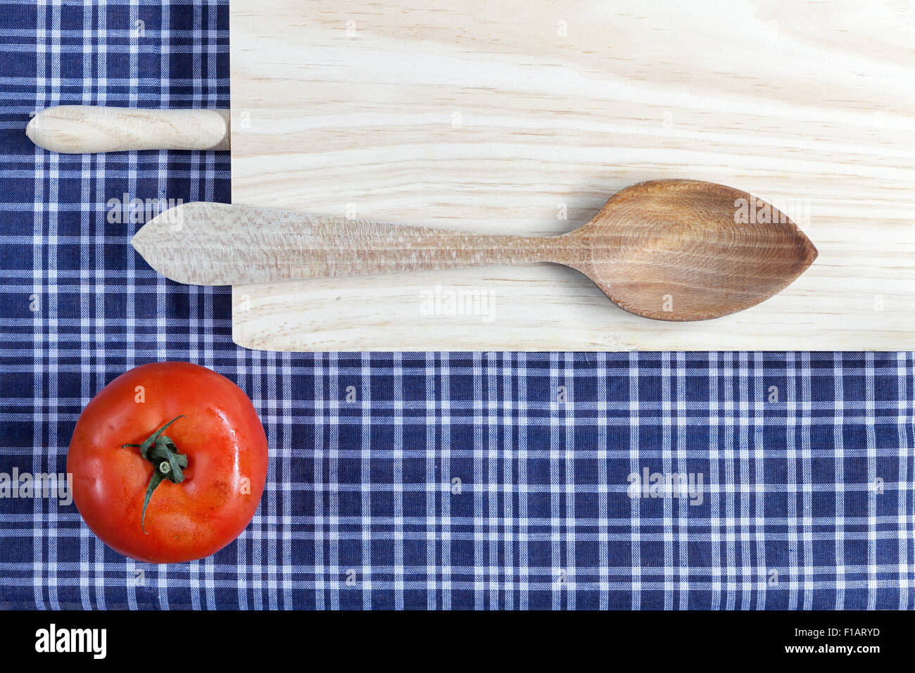 La tabella e il cucchiaio di legno su una tovaglia blu Foto Stock