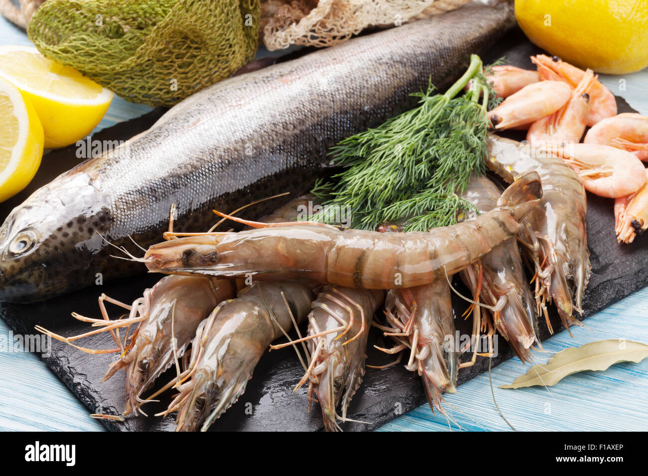 Crudo fresco il cibo del mare con spezie sulla lastra di pietra su un tavolo di legno sfondo Foto Stock