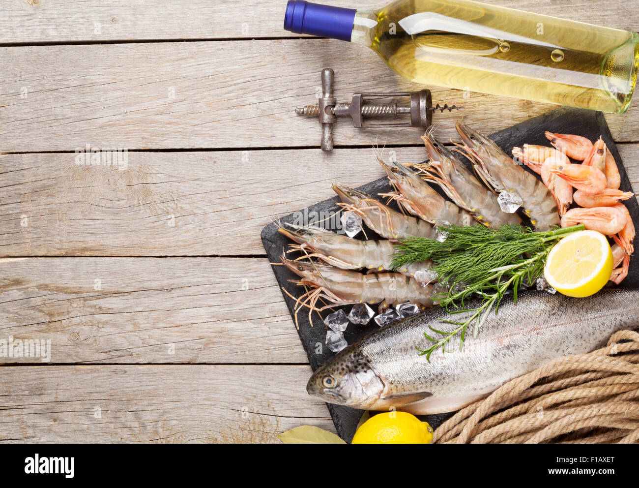 Crudo fresco il cibo del mare con spezie e vino bianco su tavola di legno dello sfondo. Vista da sopra con lo spazio di copia Foto Stock