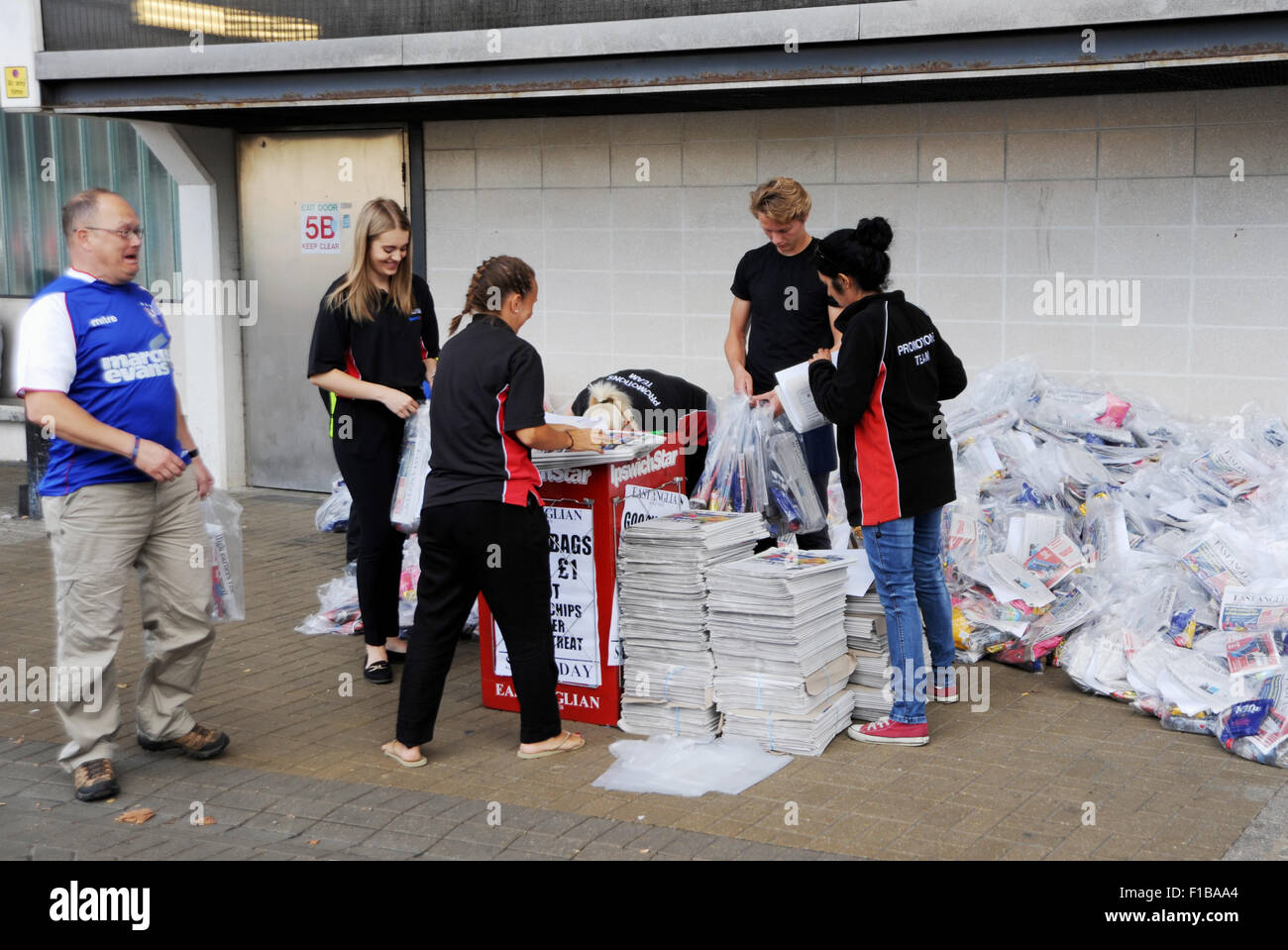 Promozione personale da East Anglian Daily Times e Ipswich stella con copie del giornale Goody sacchetti a partita di calcio Suffolk REGNO UNITO Foto Stock