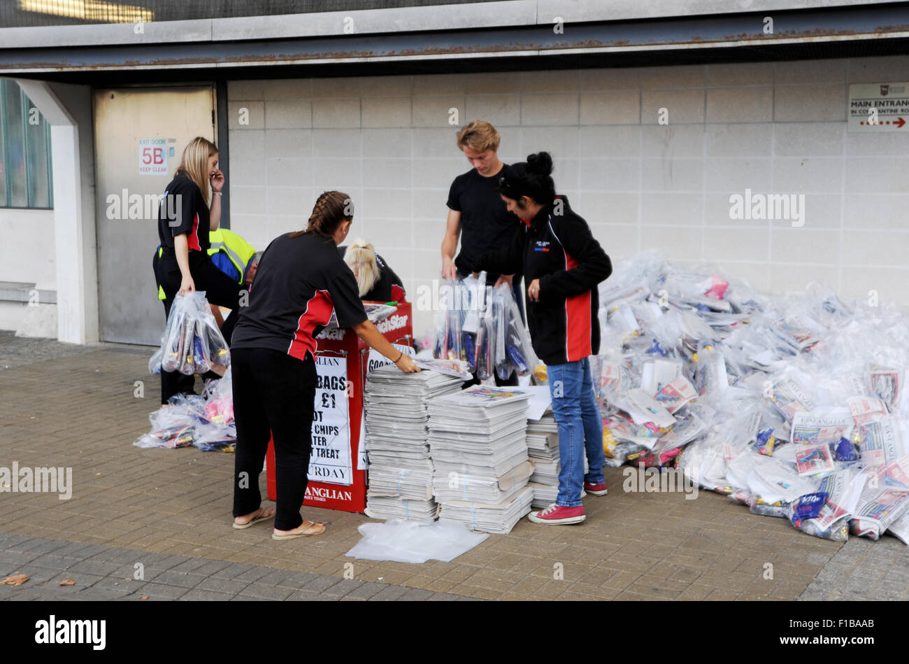 Promozione personale da East Anglian Daily Times e Ipswich stella con copie del giornale Goody sacchetti a partita di calcio Suffolk REGNO UNITO Foto Stock