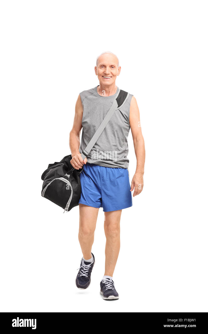 A piena lunghezza Ritratto di un uomo anziano in sportswear portando una borsa sportiva e a pochi isolati su sfondo bianco Foto Stock