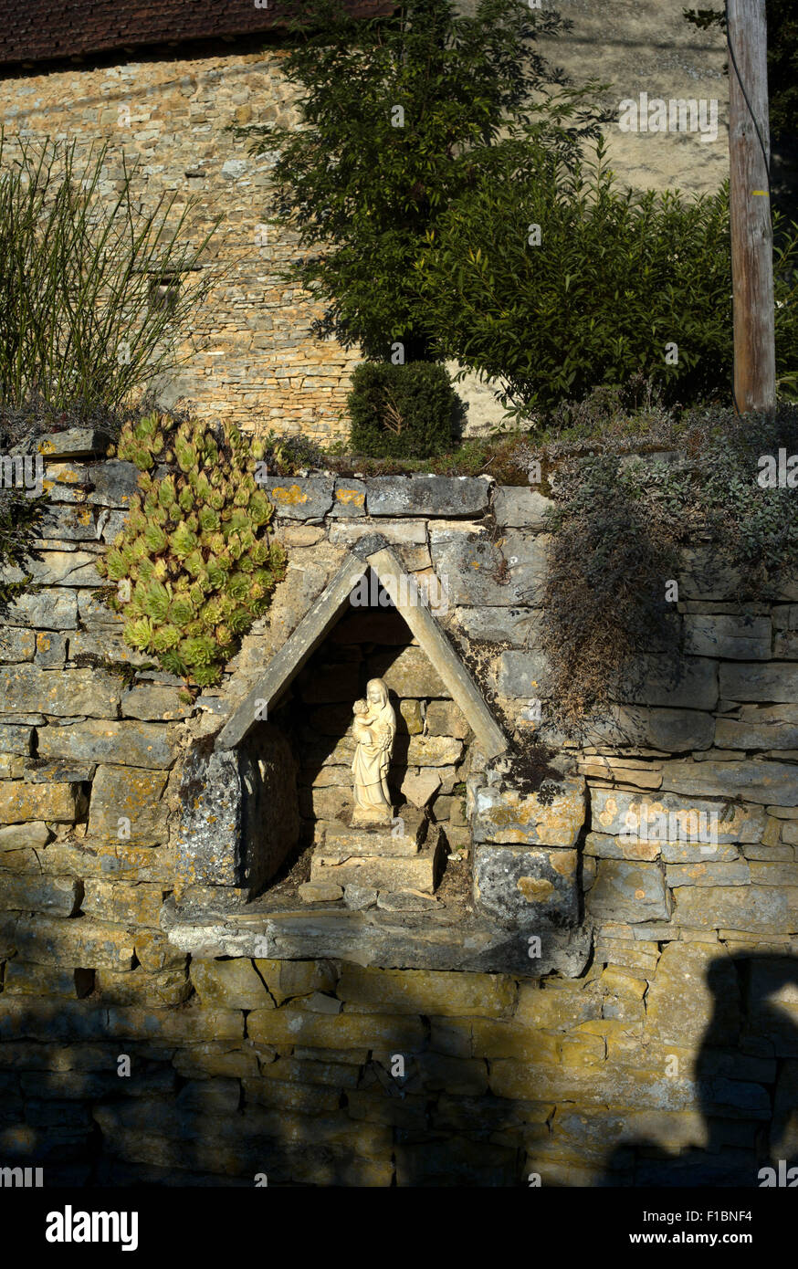 Vergine Maria e Cristo bambino in una nicchia di pietra, Pont Carral, Lot, Francia Foto Stock