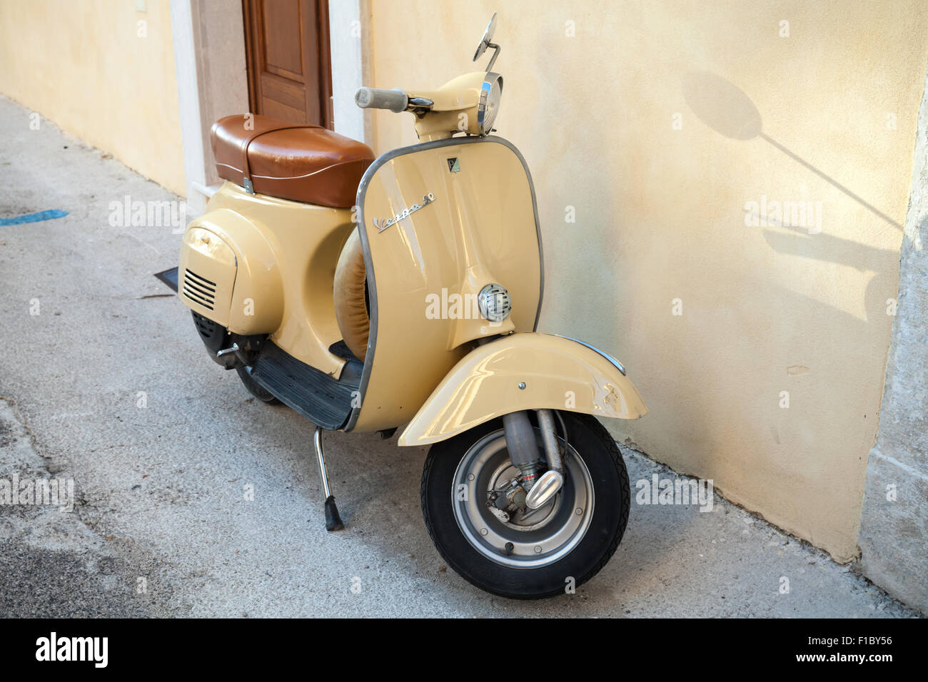 Gaeta, Italia - 19 agosto 2015: Classico giallo scooter Vespa sta parcheggiata vicino a parete Foto Stock