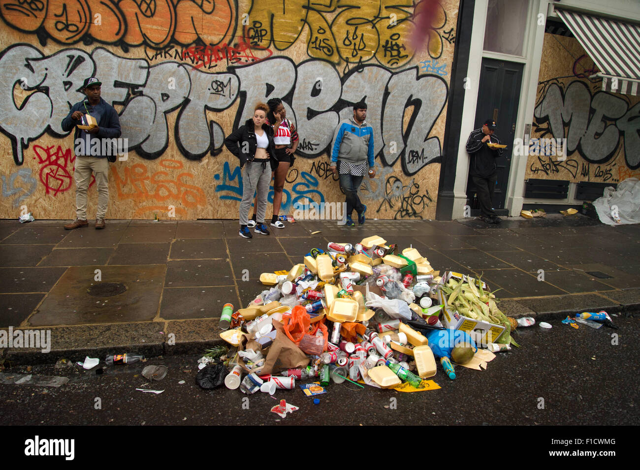 Carnevale di Notting Hill 2015. Pila di spazzatura sotto la pioggia nella parte anteriore della parete dipinta Foto Stock