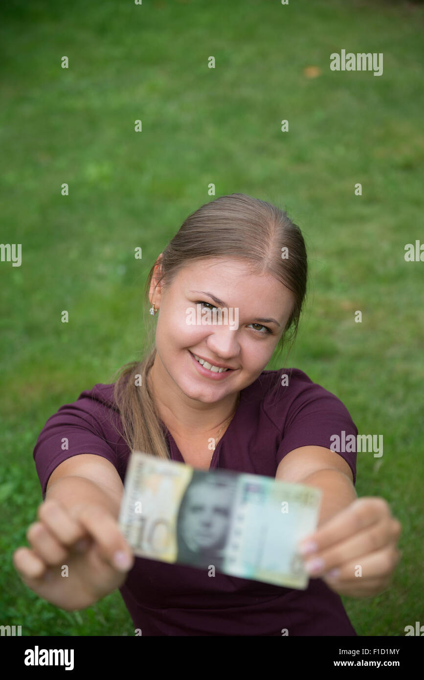 Felice giovane donna bionda azienda Swiss franc banconota Foto Stock
