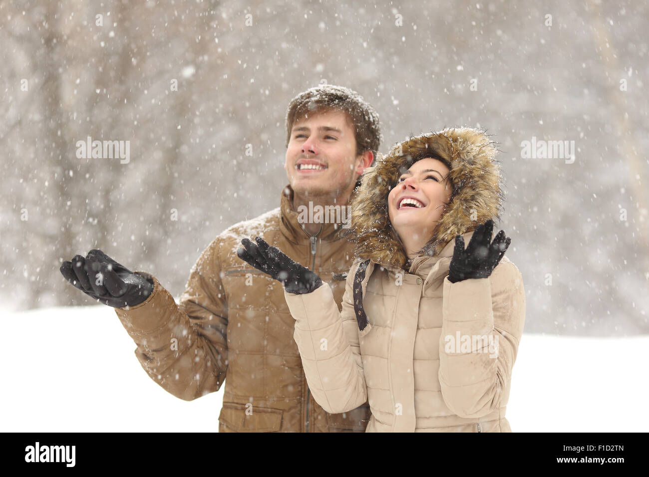 Coppia divertente guardare la neve in inverno durante una nevicata nei giorni festivi Foto Stock