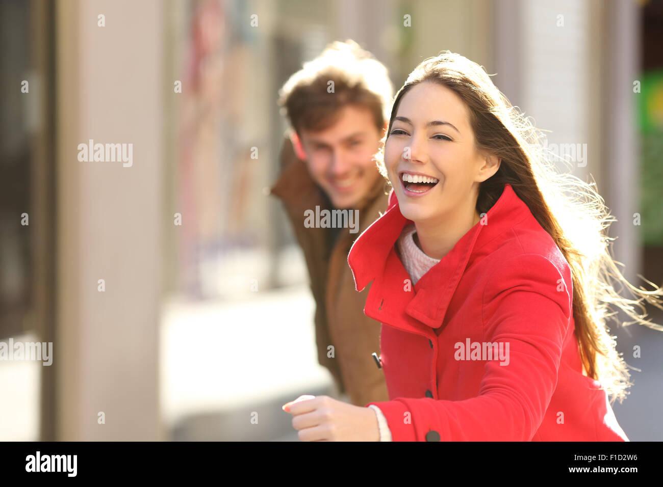 Coppia felice in esecuzione in strada in una giornata di sole Foto Stock
