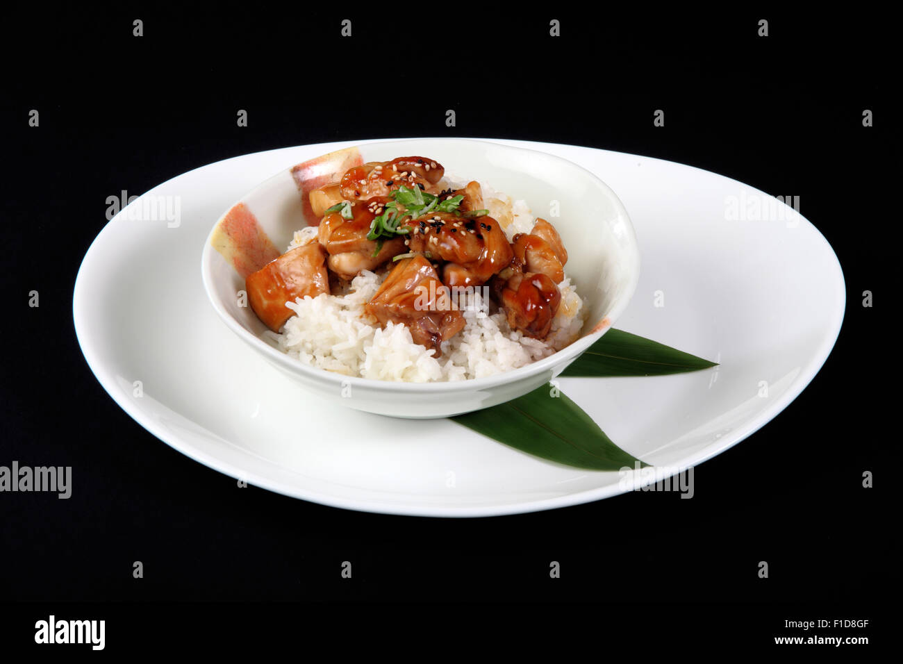 Pepite di pollo con riso in piastra bianca su sfondo nero Foto Stock